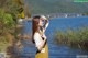 A woman standing in front of a body of water.