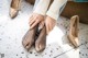 A woman is putting on her shoes on the floor.