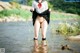 A woman in a sailor outfit is standing in the water.