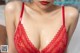A woman in a red lingerie is posing for the camera.