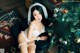 A woman in lingerie sitting next to a Christmas tree.