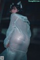 A woman in a plastic bag is standing in the dark.