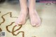 A person standing on a rug with their feet in the sand.