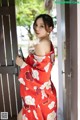 A woman in a red kimono is posing for the camera.