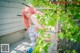 A woman with pink hair sitting on a bench.